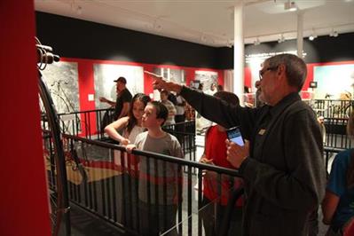 man pointing at wall with children standing around