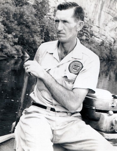 Leon Dodd An older man looking pensively as he paddles a boat in the water.