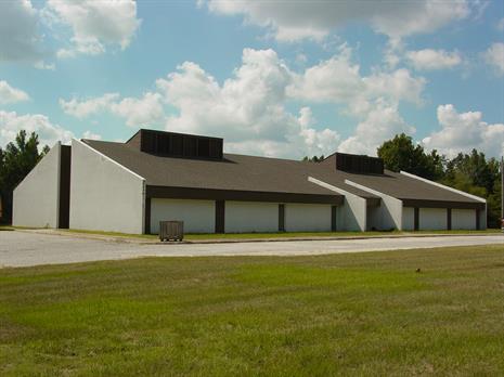 White walled building with lawn in front.